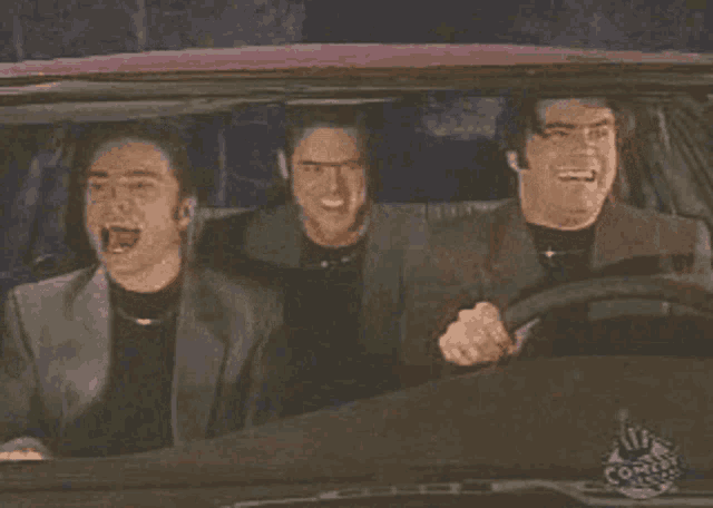 three men are driving a car with a comedy central logo on the dashboard