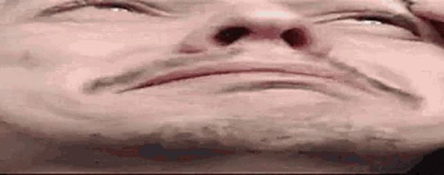 a close up of a man 's face with his eyes closed and his mouth open .