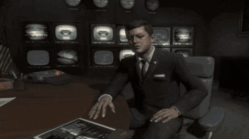 a man in a suit and tie is looking at a picture