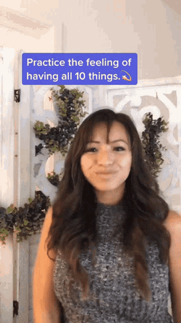a woman is standing in front of a white screen with a purple sign that says practice the feeling of having all 10 things