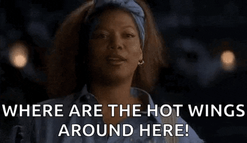a woman is laughing and saying `` where are the hot wings around here ? ''