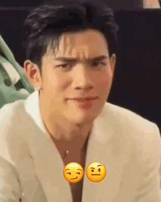 a man in a white suit is making a funny face with two smiley faces on his face .