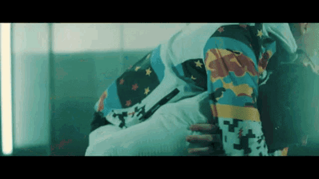 a person wearing a colorful jacket with stars on it is laying down