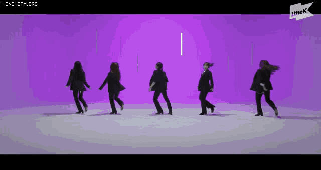 a group of women are dancing in a row on a purple background .
