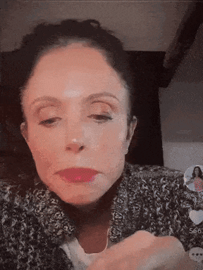 a woman in a sweater is making a funny face .
