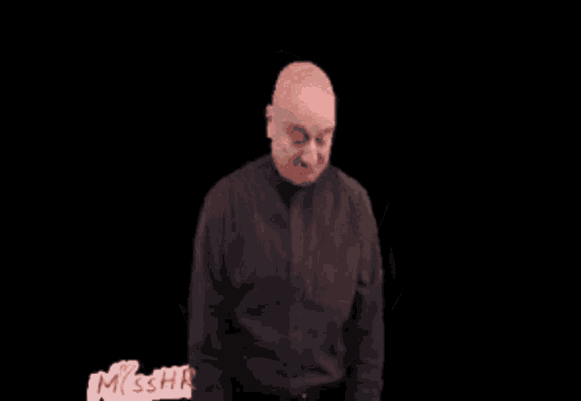 a man in a black shirt is making a funny face with the words kuch bhi ho sakta hai behind him