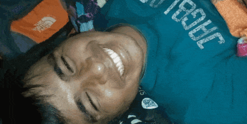 a man wearing a north face shirt is laying down and smiling