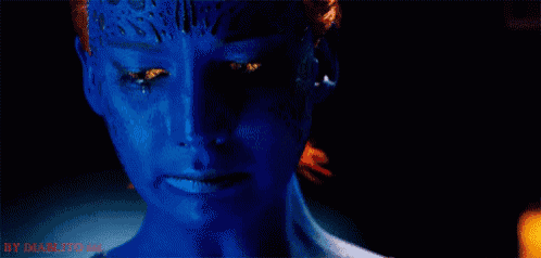 a close up of a woman 's face with blue paint on it and a tear running down her face .
