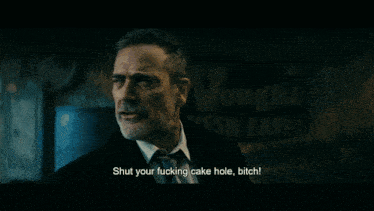 a man in a suit and tie says shut your fucking cake hole