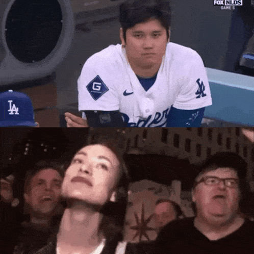 a man in a la jersey sits in the dugout
