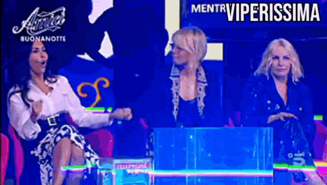 three women are sitting in front of a screen that says viperissima on it