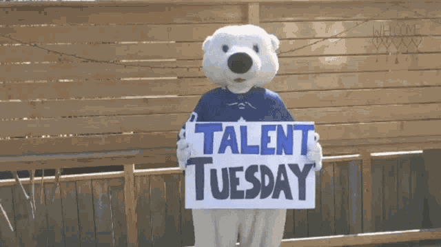 a polar bear mascot holds a sign that says talent tuesday