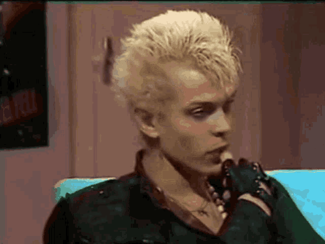 a man with blonde hair is sitting on a couch