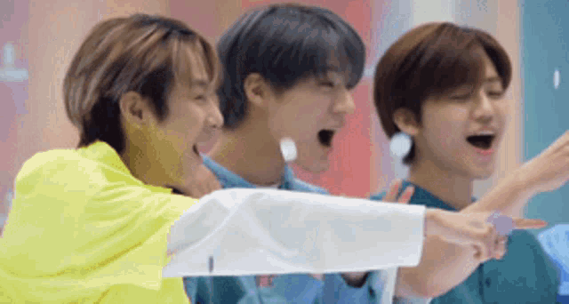 a group of young men are standing next to each other with their mouths open
