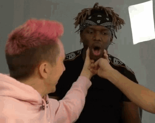 a man with pink hair is being touched by a woman