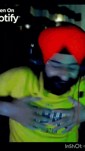 a man wearing a turban and a yellow shirt with the word spotify on the bottom right