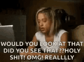 a woman is sitting in front of a laptop computer and looking at the screen .