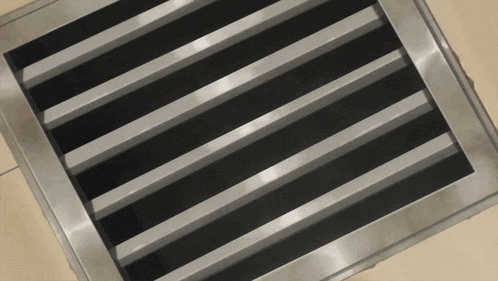 a close up of a stainless steel grate with black stripes on it