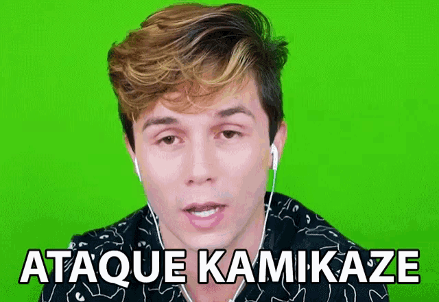 a man wearing ear buds says " ataque kamikaze " in front of a green screen