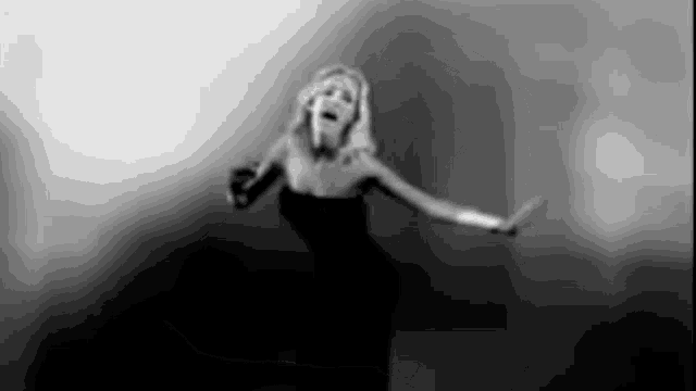 a black and white photo of a woman singing into a microphone .