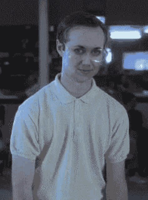 a man wearing glasses and a white polo shirt is smiling