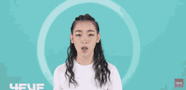 a girl in a white t-shirt is making a funny face and pointing up
