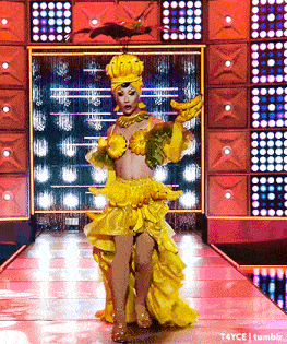 a drag queen is walking down a runway wearing a yellow banana outfit