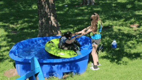 a person in a tube in a pool with a bottle of water in the grass