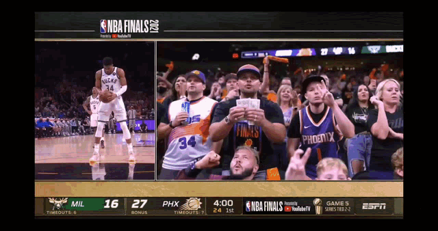 a screen shows a basketball game between the phoenix suns and the milwaukee bucks