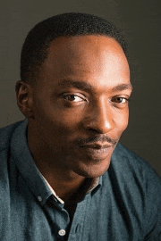 a close up of a man 's face with a blue shirt on