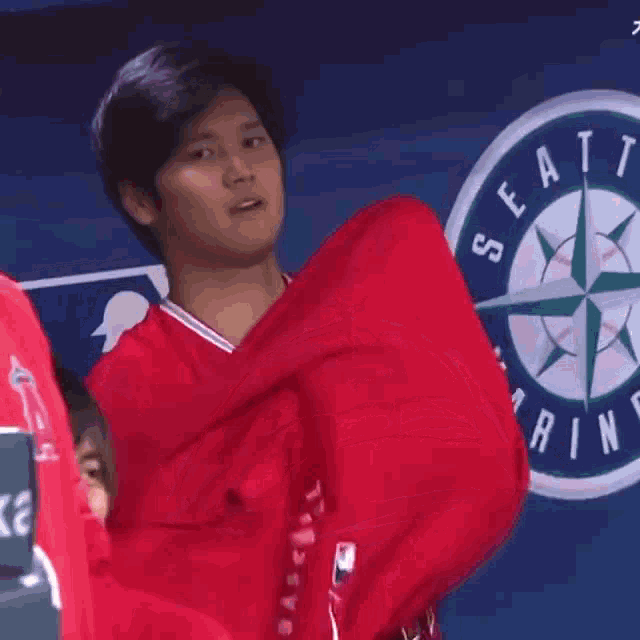 a man wearing a red hoodie that says angels baseball on it