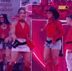 a woman in a cowboy hat is dancing on a stage with other people .