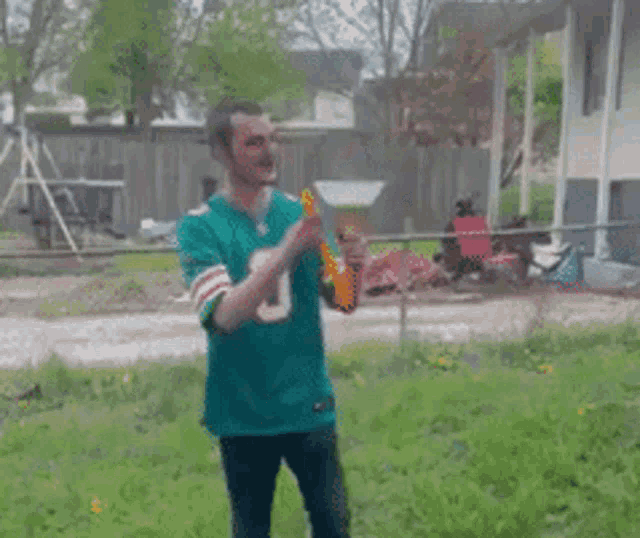 a man in a green jersey with the number 0 on it is blowing a horn