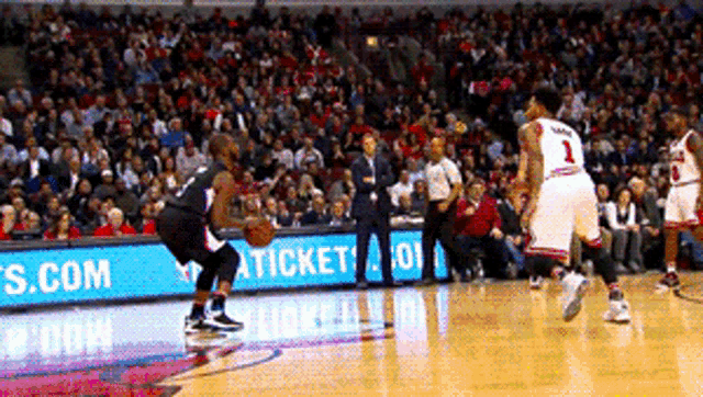 a basketball game is being played in front of a sign that says ticket on it