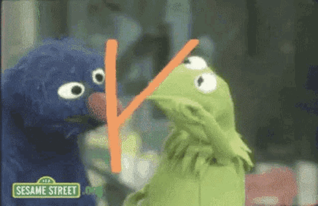kermit the frog and elmo from sesame street are standing next to each other .