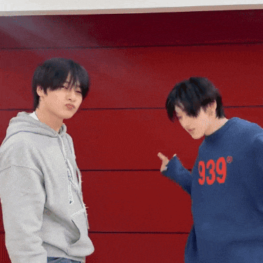 two young men standing next to each other one wearing a blue sweater that says 939