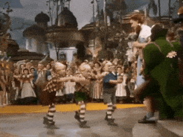 a group of children are dancing in front of a crowd in a wizard of oz scene