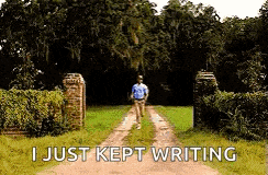 a man is running down a dirt road with the words `` i just kept writing '' written on the ground .