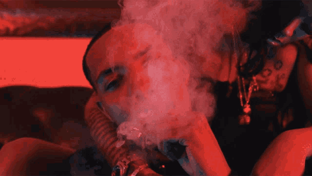 a woman is smoking a hookah in a dark room