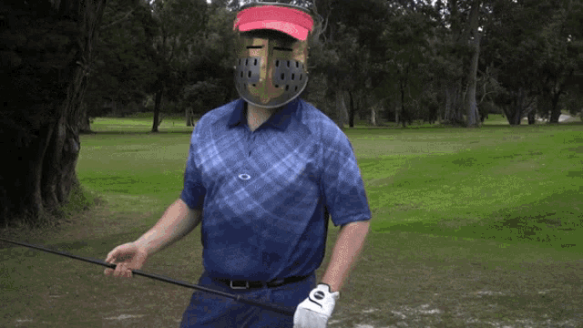 a man wearing a helmet holds a golf club on a golf course