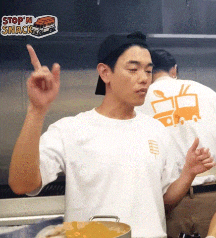 a man wearing a white shirt that says stop n snack