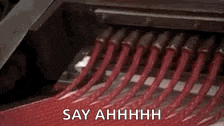 a close up of a machine making candy with the words `` say ahhhh '' written on the bottom .