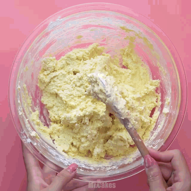 a person is mixing something in a glass bowl with the words mr.cakes below