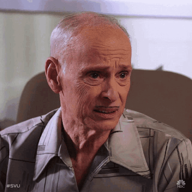 an older man sitting in a chair with a nbc logo on the bottom right