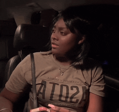 a woman sitting in a car wearing a t-shirt that says ato2