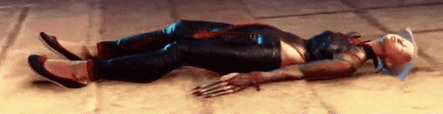 a woman is laying on the floor with blood on her face and arms .