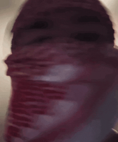 a close up of a person 's face with a scarf covering it