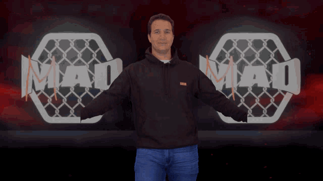 a man with his arms outstretched stands in front of a mma logo