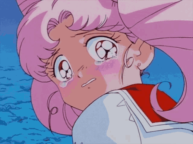 a girl with pink hair is crying and looking down