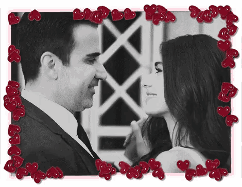 a black and white photo of a man and woman surrounded by hearts